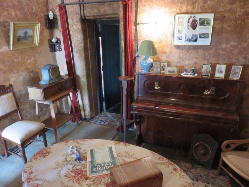 Sitting room at Mugga-Mugga showing a table, chairs and a small upright piano